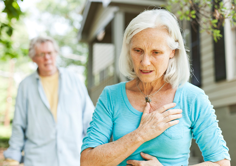 senior woman holding chest because of chest pain 