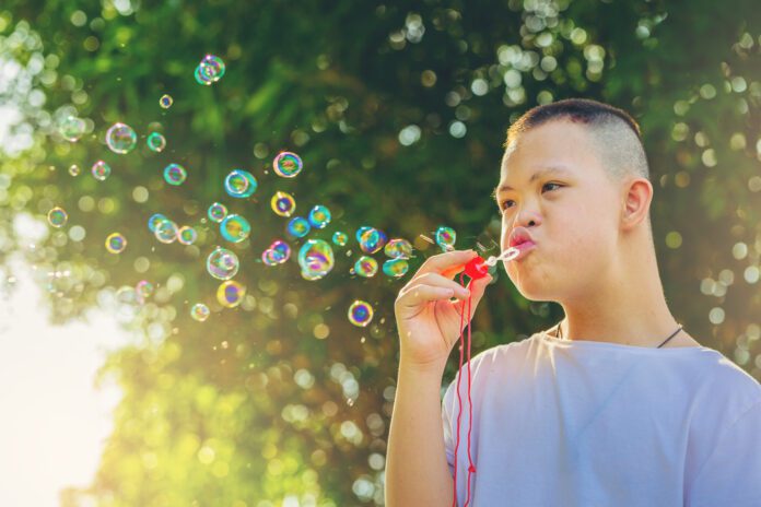 boy with down syndrome blowing bubbles