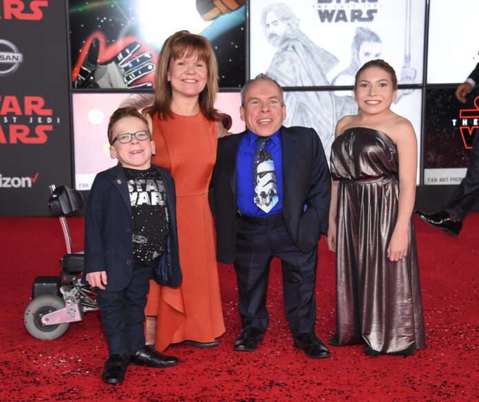 Warwick Davis on red carpet with his wife, Samantha, and their two children