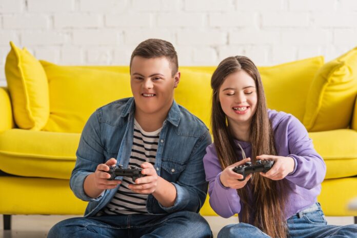 Boy and girl with special needs play adaptive video games