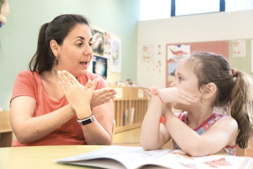 Special education teacher using ASL with student