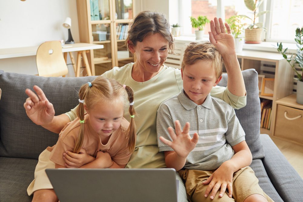 family, including a girl with Down syndrome, work on a laptop together