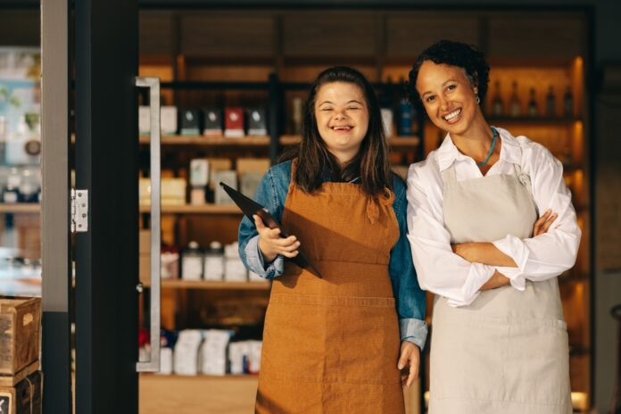 Two,Successful,Store,Employees,Smiling,At,The,Camera,While,Standing