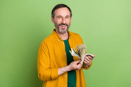 Man, smiling, holding money
