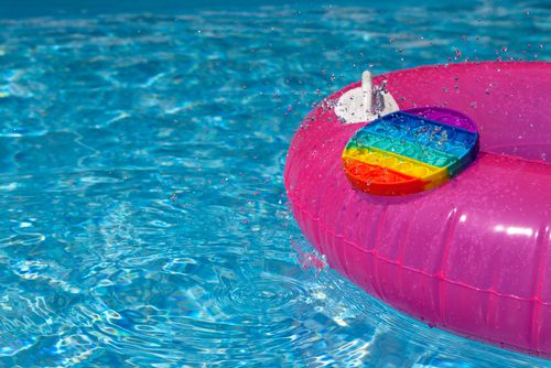 A pink pool tube with a rainbow-colored pop-it fidget. 