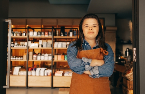 Female employee, who has Down syndrome, crosses arms and has a facial expression of disappointment.